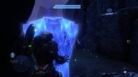 Master Chief projecting a hardlight shield in front of himself while battling a Promethean Knight.