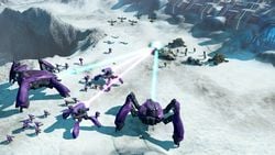 Two Deutoros-pattern Scarab and two Shua'ee-pattern Locusts firing their focus cannons at UNSC units on the Halo Wars Skirmish map Chasm.