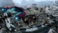 A screenshot of an early build of Halo Wars, depicting a Taaku Xur-pattern Spirit dropship flying away from Alpha Base in the eponymous level.
