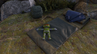 Master Chief toy on a sleeping bag.