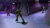 A Flood combat form chases an Unggoy Major down a corridor in Halo: Combat Evolved.