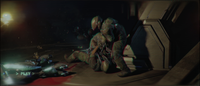 Bisenti attempts to remove a pod infector from Riley in Halo: Campaign Evolved.