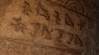 Mysterious writing on a cave wall in the trailer.